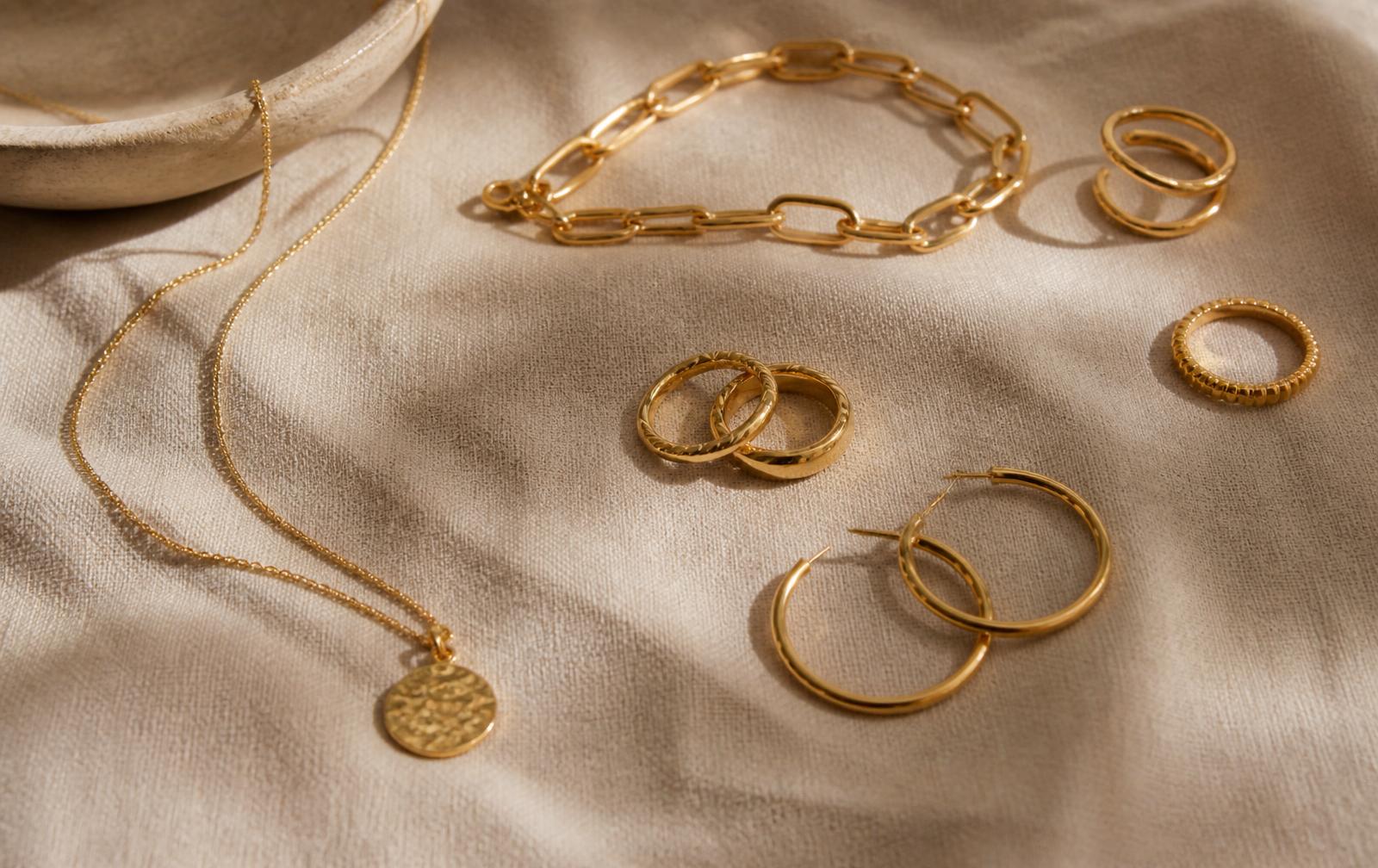 Bijoux fins en or posés sur un fond beige chaleureux